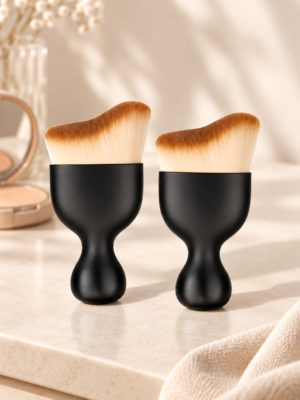 Set de dos brochas de maquillaje negras en ambiente cálido y minimalista